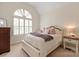 Comfortable bedroom with a large arched window, plush bedding, and stylish bedside tables at 7507 Meadowgate Ln, Waxhaw, NC 28173