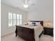 Bedroom with dark wooden bed, white linens, black nightstands, lamps, and shuttered window at 7507 Meadowgate Ln, Waxhaw, NC 28173