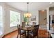 A cozy dining area featuring a round wood table, wood chairs, wood floors, and lots of natural light at 7507 Meadowgate Ln, Waxhaw, NC 28173