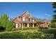 Stunning brick home with manicured landscaping and a well-maintained lawn on a clear day at 7507 Meadowgate Ln, Waxhaw, NC 28173