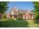 Stately brick home with manicured lawn, beautiful landscaping, and inviting front porch at 7507 Meadowgate Ln, Waxhaw, NC 28173