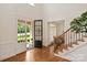 Bright foyer with hardwood floors, staircase with iron railings and a view to the front yard at 7507 Meadowgate Ln, Waxhaw, NC 28173