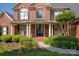 Inviting front porch with columns, arched windows and decorative landscaping, welcoming visitors to the home at 7507 Meadowgate Ln, Waxhaw, NC 28173