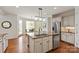 Bright kitchen with a central island, stainless steel appliances, and hardwood floors for cooking and dining at 7507 Meadowgate Ln, Waxhaw, NC 28173