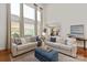 Comfortable living room featuring two sofas, ottoman, fireplace, and tall windows with lots of natural light at 7507 Meadowgate Ln, Waxhaw, NC 28173