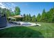 Backyard featuring in-ground pool, lounge chairs, and well-maintained lawn surrounded by mature trees at 7507 Meadowgate Ln, Waxhaw, NC 28173