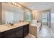 Bright bathroom features a double vanity, soaking tub, and tiled floors at 8726 Addingham Dr, Charlotte, NC 28269