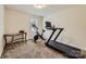 Spare bedroom featuring exercise equipment, carpet and a window providing natural light to the space at 8726 Addingham Dr, Charlotte, NC 28269
