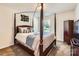 Well-lit bedroom features a beautiful canopy bed with decorative pillows and a wardrobe at 8726 Addingham Dr, Charlotte, NC 28269