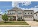 Charming two-story home with gray siding, well-manicured lawn, and attached two-car garage, under a partly cloudy blue sky at 8726 Addingham Dr, Charlotte, NC 28269