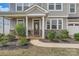 Inviting front porch with stone accents and meticulously landscaped garden beds leading to the front door at 8726 Addingham Dr, Charlotte, NC 28269