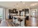 Well-lit kitchen with dark cabinets, stainless steel appliances, a granite island, and modern pendant lighting at 8726 Addingham Dr, Charlotte, NC 28269