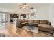 Spacious living room features a leather sectional, wood floors, and an open layout flowing into the kitchen at 8726 Addingham Dr, Charlotte, NC 28269