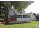 Home featuring large backyard with wood deck, sunroom, and a view of the house's backyard at 9315 Pebble Creek Way, Charlotte, NC 28269