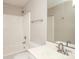 Bright bathroom features a shower-tub combo with white tile surround, and a white vanity sink at 9315 Pebble Creek Way, Charlotte, NC 28269