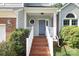 Inviting front porch with wooden steps and white railings leading to a blue front door at 9315 Pebble Creek Way, Charlotte, NC 28269