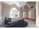 Bright living room with vaulted ceilings, a large window, and a comfortable black sofa at 9315 Pebble Creek Way, Charlotte, NC 28269