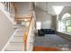 Staircase leading to a bright living area with a vaulted ceiling and comfortable seating at 9315 Pebble Creek Way, Charlotte, NC 28269