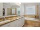 Bathroom with double sink vanity, soaking tub, and tiled shower stall at 10401 Royal Winchester Dr, Charlotte, NC 28277