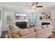 Comfortable living room features a ceiling fan, fireplace, and large windows providing ample natural light at 10401 Royal Winchester Dr, Charlotte, NC 28277