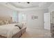 Bright primary bedroom featuring neutral paint, carpet, and an ensuite bathroom at 10401 Royal Winchester Dr, Charlotte, NC 28277