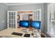 Well-lit home office featuring double glass doors and modern monitors for a comfortable work environment at 10401 Royal Winchester Dr, Charlotte, NC 28277