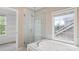Bright bathroom features a luxurious bathtub, glass shower, and a large window at 10616 Back Ridge Rd, Charlotte, NC 28277