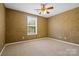 Cozy bedroom features plush carpeting, a ceiling fan, and a window for natural light at 10616 Back Ridge Rd, Charlotte, NC 28277
