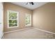 Light filled bedroom with tan walls, wall to wall carpet, and large windows at 10616 Back Ridge Rd, Charlotte, NC 28277