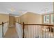 Bright hallway with hardwood railing, crown molding, and chandelier over the foyer at 10616 Back Ridge Rd, Charlotte, NC 28277