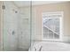 Bright bathroom features a luxurious bathtub, glass shower, and a large window at 10616 Back Ridge Rd, Charlotte, NC 28277