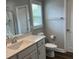 Bright bathroom with a vanity, toilet, shower behind a clear glass door and a window at 1119 Balls Creek Rd, Claremont, NC 28610