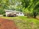 Spacious backyard with a deck, lush lawn, and mature trees, providing a serene outdoor space at 1300 Rutledge Ave, Charlotte, NC 28211