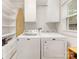 Functional laundry room featuring modern white appliances, built-in shelves, and plenty of storage at 1300 Rutledge Ave, Charlotte, NC 28211