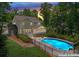 View of a backyard pool with patio area and screened porch on a charming home, surrounded by lush greenery and a privacy fence at 1328 Huntcliff Dr, Waxhaw, NC 28173