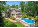 View of a backyard pool with patio area and screened porch on a charming home, surrounded by lush greenery and a privacy fence at 1328 Huntcliff Dr, Waxhaw, NC 28173