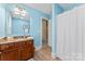 Well-lit bathroom with granite counters, wooden cabinets, and light blue walls at 1328 Huntcliff Dr, Waxhaw, NC 28173