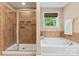 Bathroom with tiled shower, soaking tub, and window providing natural light at 1328 Huntcliff Dr, Waxhaw, NC 28173