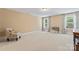 Large bonus room with neutral walls, carpeted floor, windows and sitting chair at 1328 Huntcliff Dr, Waxhaw, NC 28173