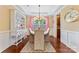 Elegant dining room with hardwood floors, wainscoting, a tray ceiling, and a stylish chandelier above the table at 1328 Huntcliff Dr, Waxhaw, NC 28173