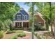 Charming two-story home featuring a mix of brick and blue siding, a welcoming porch, and lush landscaping at 1328 Huntcliff Dr, Waxhaw, NC 28173