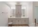 Well-lit bathroom featuring double sinks with cabinetry and drawers, mirrors, and modern fixtures at 1428 Spring Ridge Ln, Denver, NC 28037