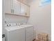 Bright laundry room with white cabinets and modern washer and dryer at 1428 Spring Ridge Ln, Denver, NC 28037