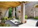 Charming covered patio with brick columns, overhead wood and lush landscaping at 1428 Spring Ridge Ln, Denver, NC 28037
