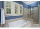 Bright bathroom featuring a soaking tub with jets and a tiled walk-in shower with a glass door at 154 Patterson'S Bridge None, New London, NC 28127