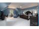 Blue hued bedroom featuring a sitting area, dormer window, and a custom bed frame with floral bedding at 154 Patterson'S Bridge None, New London, NC 28127