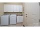 Bright laundry room with white cabinets, modern washer and dryer, and a utility sink at 154 Patterson'S Bridge None, New London, NC 28127