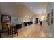 Large recreation room with a pinball machine, shuffleboard table, bar, and light wood floors at 154 Patterson'S Bridge None, New London, NC 28127