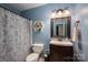 Charming bathroom with a stylish vanity, decorative mirror, and patterned shower curtain at 1774 Smyrna Ln, Catawba, NC 28609