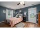 Comfortable bedroom with a pink quilt, ceiling fan, wood-look flooring, and a door leading to the outside at 1774 Smyrna Ln, Catawba, NC 28609